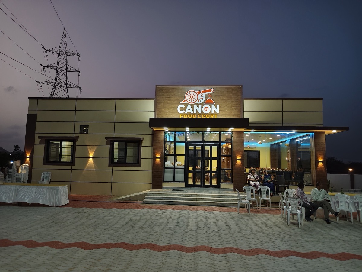 Canon Food Court building lit up at dusk with guests seated outside