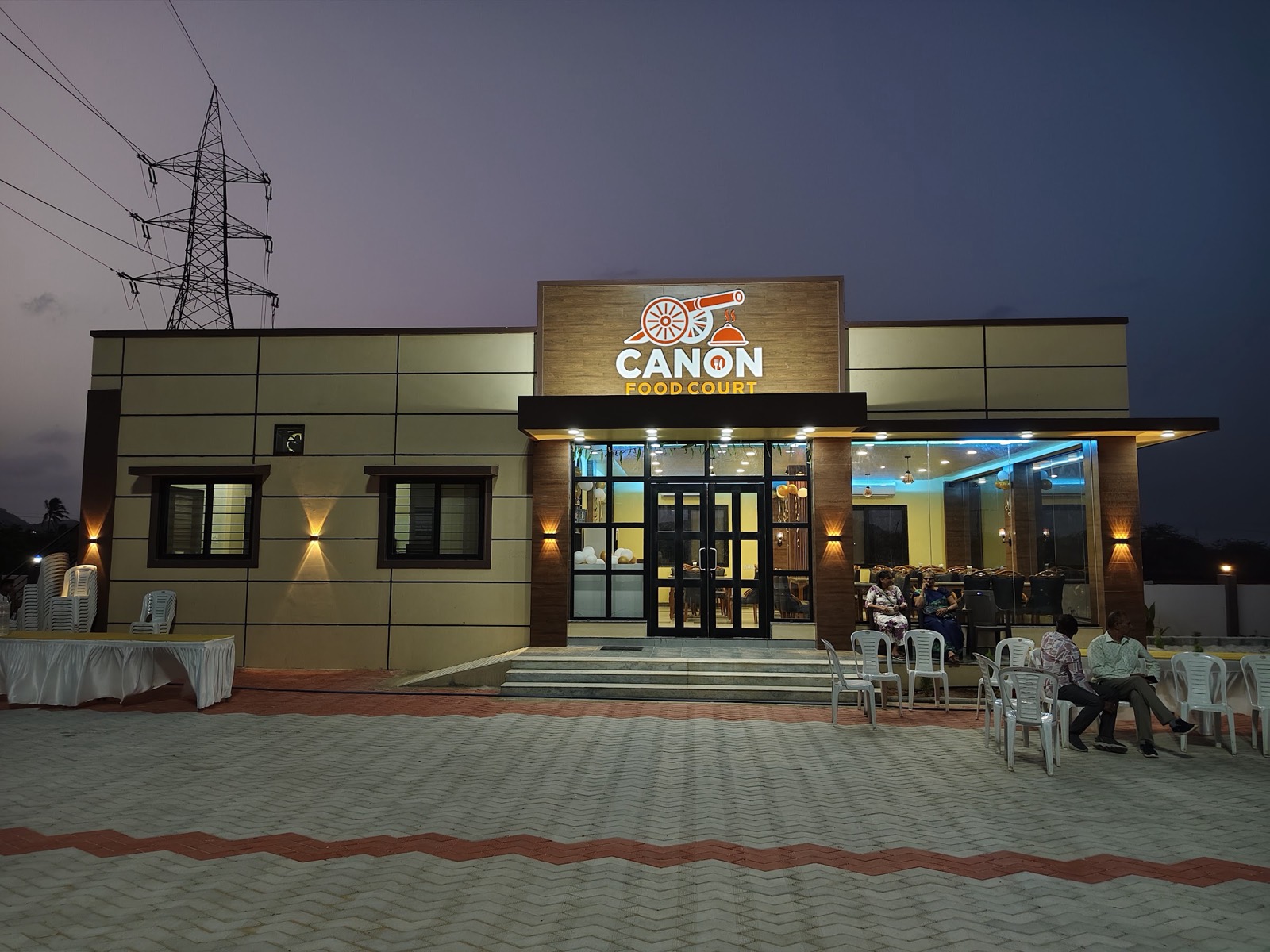 Canon Food Court at dusk with guests seated outside